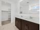 Bright, stylish bathroom featuring a double vanity, walk-in closet and walk-in shower for a serene, spa-like retreat at 8554 W Trenton Ct, Florence, AZ 85132
