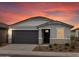 Charming single-story home with gray stucco, well-manicured landscaping and beautiful sunset backdrop at 8554 W Trenton Ct, Florence, AZ 85132