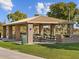 Covered picnic pavilion with stone columns, picnic tables, and lush green lawn at 8554 W Trenton Ct, Florence, AZ 85132
