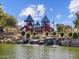 playground with slides and climbing structures overlooking a serene pond with a small waterfall at 8554 W Trenton Ct, Florence, AZ 85132