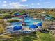 An aerial view of a community water park featuring pools, slides, and splash pads under a sunny sky at 8554 W Trenton Ct, Florence, AZ 85132