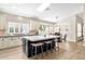 Well-lit kitchen features a marble island with seating, stainless steel appliances, and wood-look tile flooring at 8657 E Aster Dr, Scottsdale, AZ 85260