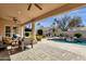 Inviting covered patio with comfortable seating overlooks a pristine pool and lush landscaping at 8657 E Aster Dr, Scottsdale, AZ 85260