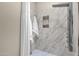 Marble shower featuring a rainfall shower head and built-in niche at 8657 E Aster Dr, Scottsdale, AZ 85260