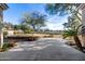 Spacious backyard featuring a large patio area, mature trees, and a view of the community at 9360 E Milagro Ave, Mesa, AZ 85209