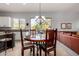 Open dining area with a chandelier, wood table, and chairs next to the kitchen and living room at 9360 E Milagro Ave, Mesa, AZ 85209