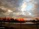 Scenic golf course view at sunset with colorful sky and pond surrounded by mature trees at 9360 E Milagro Ave, Mesa, AZ 85209