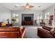 Spacious living room with leather furniture, carpeted floors, ceiling fan, and large windows for natural light at 9360 E Milagro Ave, Mesa, AZ 85209