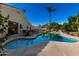 A uniquely shaped pool surrounded by a patio and seating area for endless outdoor enjoyment at 9360 E Milagro Ave, Mesa, AZ 85209