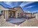 A covered back patio and a concrete backyard with decorative rock landscaping at 9404 W Pierson St, Phoenix, AZ 85037