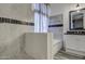 Bathroom featuring a soaking tub, tiled walls, and dual vanities at 9404 W Pierson St, Phoenix, AZ 85037