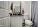 Cozy bathroom featuring a granite-topped vanity, toilet and framed mirror above the sink at 9404 W Pierson St, Phoenix, AZ 85037