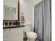 Well-lit bathroom with a granite-topped vanity and a decorative wood-framed mirror at 9404 W Pierson St, Phoenix, AZ 85037