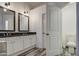 Bathroom featuring a double sink vanity with black countertops and a separate toilet room at 9404 W Pierson St, Phoenix, AZ 85037