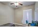 Bedroom featuring a ceiling fan and a small animal cage near a window with light curtains at 9404 W Pierson St, Phoenix, AZ 85037