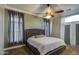 Cozy bedroom featuring a tufted headboard, neutral decor, and a ceiling fan at 9404 W Pierson St, Phoenix, AZ 85037