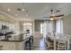 Dining area open to the kitchen, featuring an island with stool seating, wood-look tile floors, and modern lighting at 9404 W Pierson St, Phoenix, AZ 85037