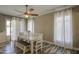 Charming dining room featuring a rustic white table, bench, and wood-look tile flooring, perfect for Gathering gatherings at 9404 W Pierson St, Phoenix, AZ 85037