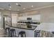 Modern kitchen with a black countertop island, white cabinets, subway tile backsplash, and stainless steel appliances at 9404 W Pierson St, Phoenix, AZ 85037