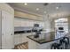 Well-lit kitchen featuring white cabinetry, dark countertops, and stainless steel appliances at 9404 W Pierson St, Phoenix, AZ 85037