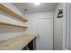 Bright laundry room with shiplap walls, wooden shelving, and modern washer/dryer at 9404 W Pierson St, Phoenix, AZ 85037