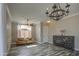 Bright living room features stylish wood-look tile flooring, a chandelier, and window with natural light at 9404 W Pierson St, Phoenix, AZ 85037