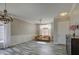 Bright living room features stylish wood-look tile flooring, a chandelier, and window with natural light at 9404 W Pierson St, Phoenix, AZ 85037