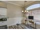 Cozy office space with a wooden desk, chair, decorative chandelier, wainscoting detail and a large window for natural light at 9404 W Pierson St, Phoenix, AZ 85037