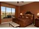 Comfortable bedroom with a decorative bed and bench seating, complemented by scenic outdoor views through a large window at 9715 N Azure Ct # 4, Fountain Hills, AZ 85268