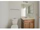 Modest bathroom features a wood vanity, toilet and mirror at 1016 E Saddleback Pl, San Tan Valley, AZ 85143