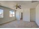 Bedroom with ceiling fan features two large windows, neutral carpet, and white walls at 1016 E Saddleback Pl, San Tan Valley, AZ 85143