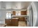 Bright kitchen with a central island, stainless steel refrigerator, and sliding glass door at 1016 E Saddleback Pl, San Tan Valley, AZ 85143