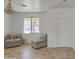 Cozy living room with neutral-toned chairs, tiled floors, and a stylish chandelier at 1016 E Saddleback Pl, San Tan Valley, AZ 85143