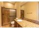 Bathroom with tile floors, granite countertops, dark cabinets, a toilet and a walk in shower at 10657 E Evergreen St, Mesa, AZ 85207