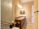 Bathroom featuring double sinks, granite countertops, wood cabinets and a mirror at 10657 E Evergreen St, Mesa, AZ 85207