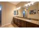 Bathroom with double sinks, granite countertops, dark cabinets and large mirror at 10657 E Evergreen St, Mesa, AZ 85207