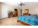 Spacious bedroom with tan carpet, ceiling fan and light, wood furniture and entry to the bathroom at 10657 E Evergreen St, Mesa, AZ 85207