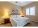 Bedroom with neutral walls, carpet, ceiling fan, bedside tables with lamps and a window with shutters at 10657 E Evergreen St, Mesa, AZ 85207