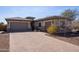 Charming home exterior featuring a paved driveway, three-car garage, and well-manicured landscaping at 10657 E Evergreen St, Mesa, AZ 85207