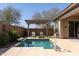 Backyard oasis showcasing a pool with water feature, pergola, artificial grass, and lounge chairs at 10657 E Evergreen St, Mesa, AZ 85207