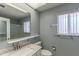 Bright bathroom featuring a large mirror, window, vanity, and tub shower at 10701 W Mountain View Rd, Sun City, AZ 85351