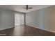 A spacious bedroom with modern ceiling fan, window, and wood-look vinyl flooring at 10701 W Mountain View Rd, Sun City, AZ 85351