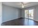 A spacious bedroom with modern ceiling fan, window, and wood-look vinyl flooring at 10701 W Mountain View Rd, Sun City, AZ 85351