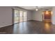 Expansive living room with dark floors, fan and sliding doors leading outside at 10701 W Mountain View Rd, Sun City, AZ 85351