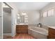 Bathroom featuring a soaking tub, a walk-in shower and wooden cabinets at 11413 E Neville Ave, Mesa, AZ 85209