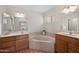 Bright bathroom with dual vanity, soaking tub, and window for natural light at 11413 E Neville Ave, Mesa, AZ 85209