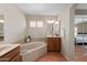 Spacious bathroom with tub, shower, wooden vanity, and neutral decor at 11413 E Neville Ave, Mesa, AZ 85209