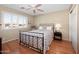 Cozy bedroom featuring hardwood floors, plantation shutters, and a ceiling fan at 11413 E Neville Ave, Mesa, AZ 85209