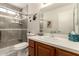 Bathroom featuring a glass shower, gray tiles, and a wood vanity with a white countertop and vessel sink at 11830 S Paiute St, Phoenix, AZ 85044