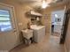 Well-lit laundry room with tile flooring, a utility sink, washer and dryer and access to the kitchen at 11830 S Paiute St, Phoenix, AZ 85044